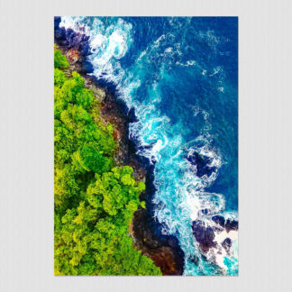 Waves crashing on the rocky shoreline of a lush green jungle island in Panama.