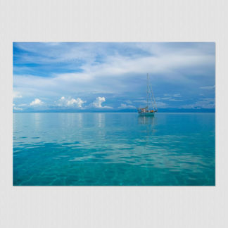 The serene setting of sailboat floating in a clear blue water lagoon at Escudo Island, Panama.