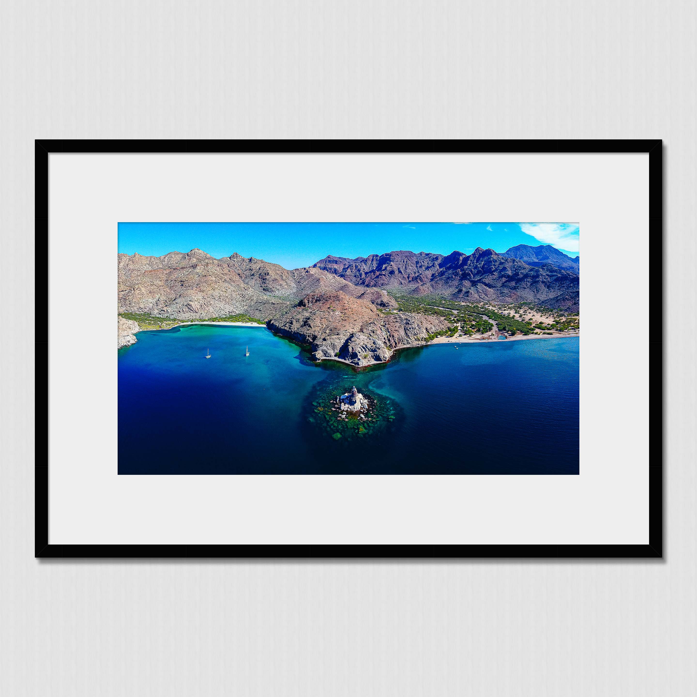 High elevation aerial photo of majestic mountain range and stunning water front in Aqua Verde Bay, Baja, Mexico