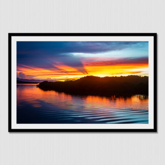 Radiant sunburst colors of wild cloud formations and rippled water at Redfrog, Bocas Del Toro, Panama