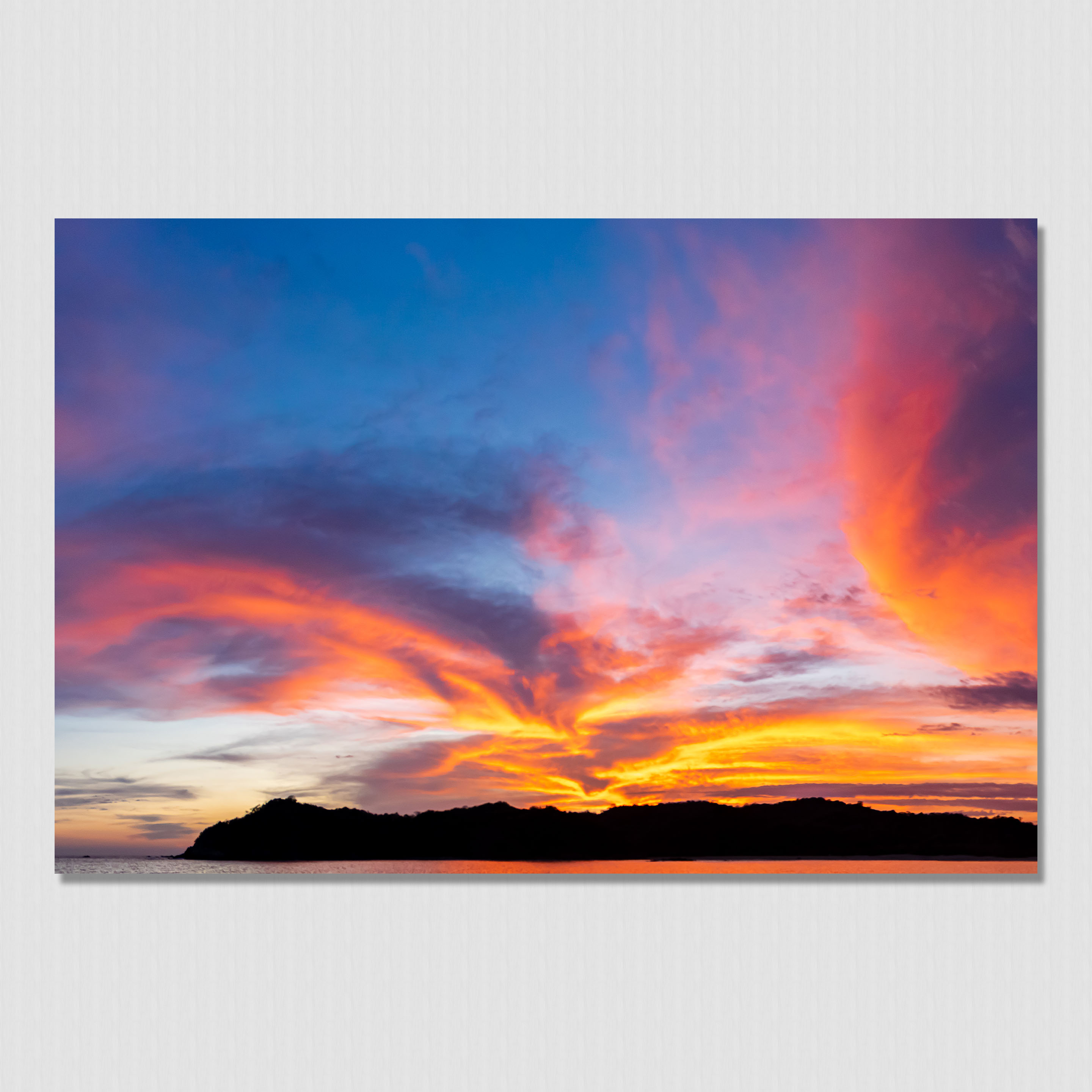 Stunning clouds illuminated by the setting sun behind the island mountains in Boca Chica, Panama