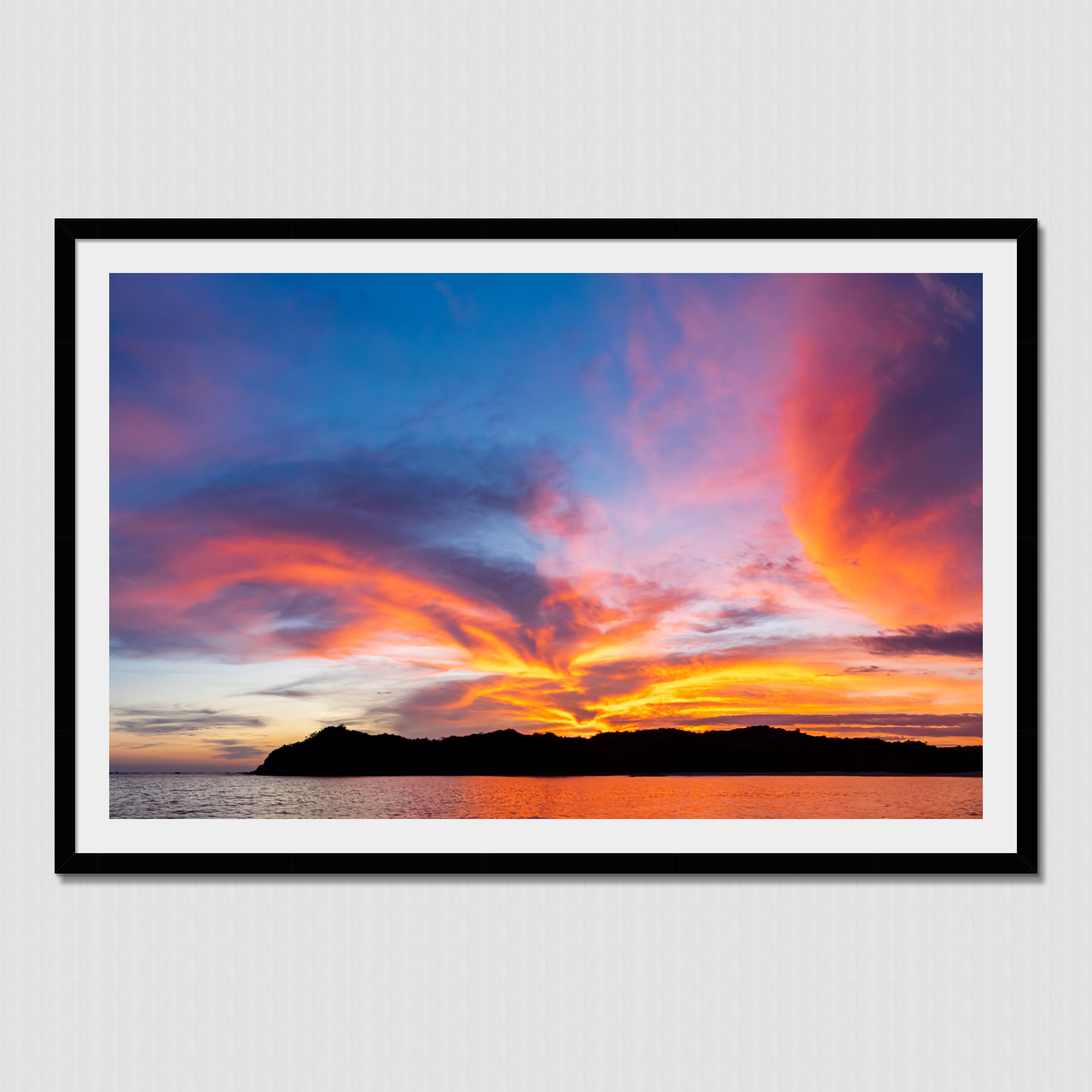 Stunning clouds illuminated by the setting sun behind the island mountains in Boca Chica, Panama