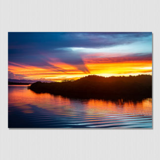 Radiant sunburst colors of wild cloud formations and rippled water at Redfrog, Bocas Del Toro, Panama