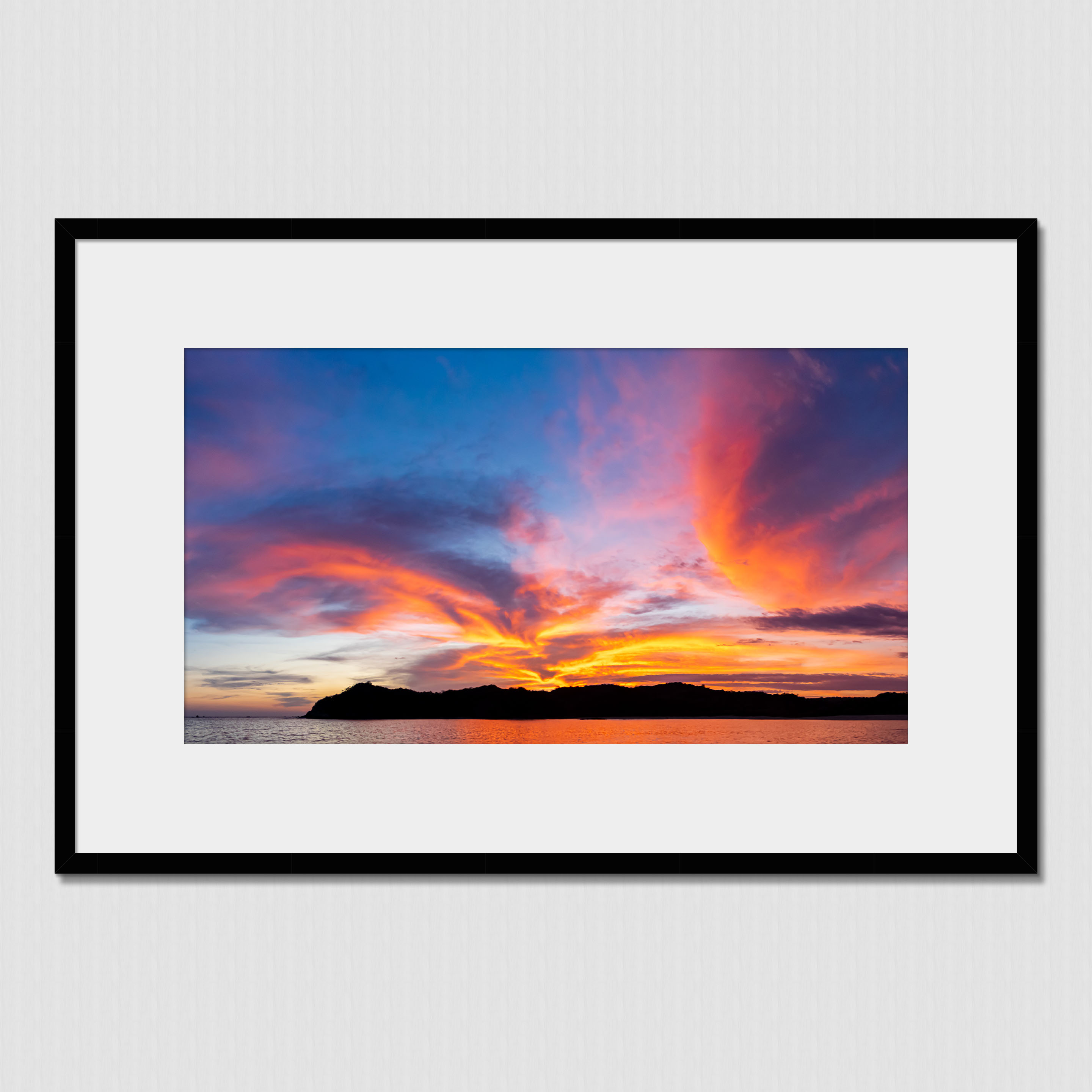 Stunning clouds illuminated by the setting sun behind the island mountains in Boca Chica, Panama