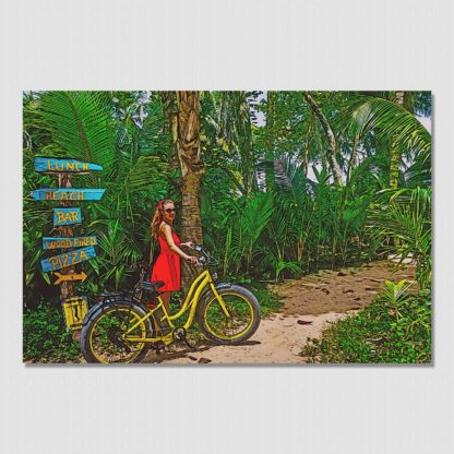 Beautiful beach girl walking her bike down the palm tree lined trail to ocean paradise.