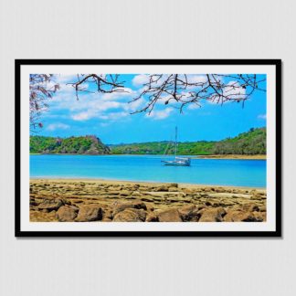 Sailboat floating in the distance with tree fringed frame and rocky beach, with oil paint effect. Photo was taken in Las Perlas Islands, Pacific Panama.