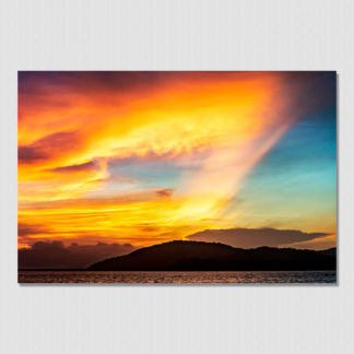 Bright orange and red color bursts through amazing cloud formations during a sunset over Pacific Panama.